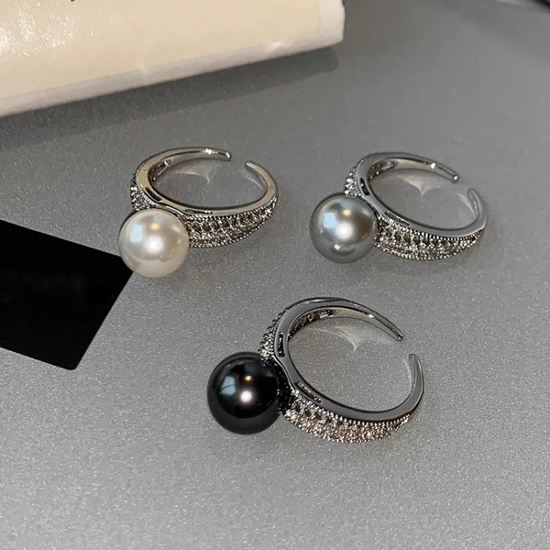 Adjustable geometric copper open finger ring in black pearl colour on grey background