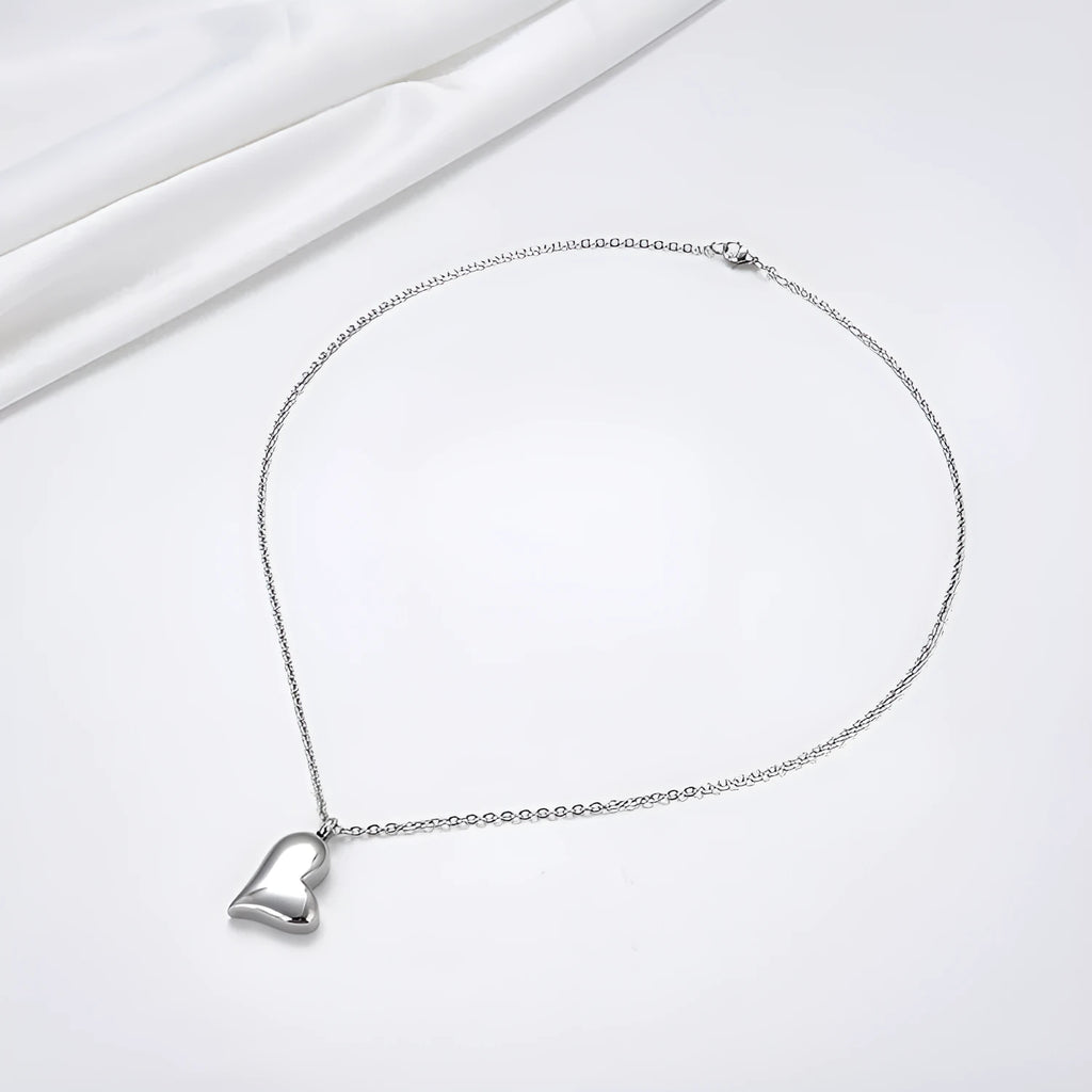 Silver coloured curved peach heart pendant necklace on a stainless steel chain with extension.