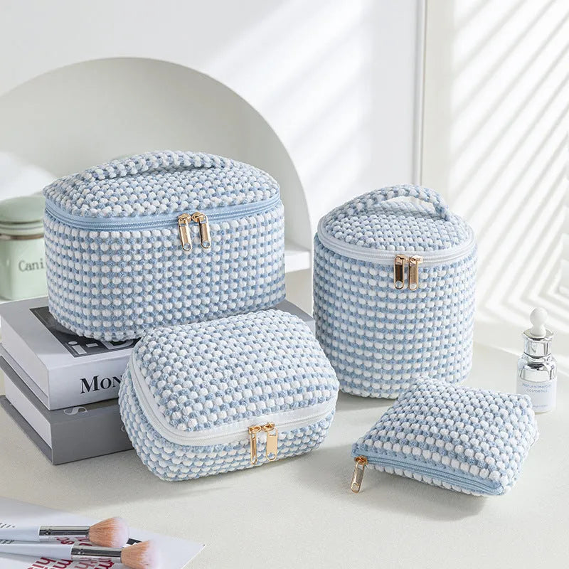 Four cube makeup bags in blue with dots pattern arranged as travel set