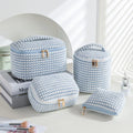 Four cube makeup bags in blue with dots pattern arranged as travel set