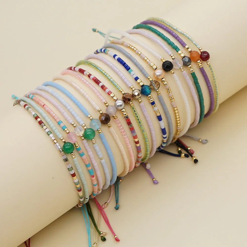 Handmade bohemian bracelet with semi-precious stone and colourful glass beads on a wrist.