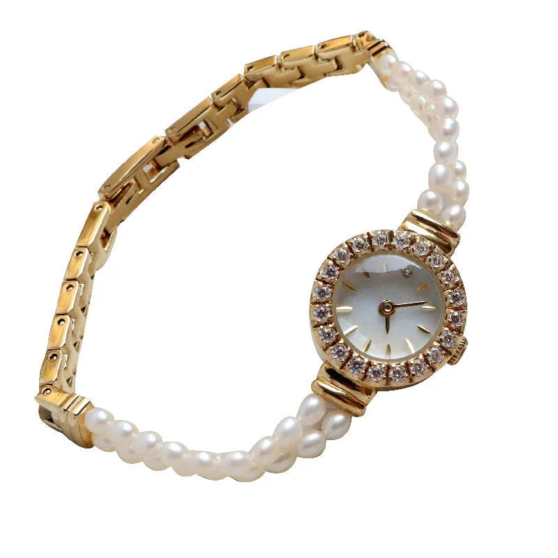 Women's light gold bracelet watch with freshwater pearls on a round 18mm dial.