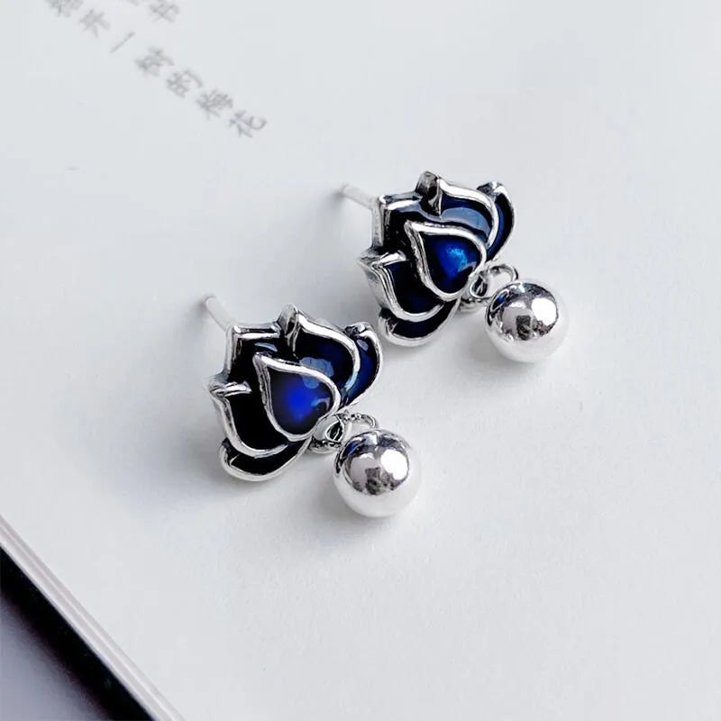 A pair of alloy lotus ear studs with retro seedpod tassel design, shown in lotus colour.
