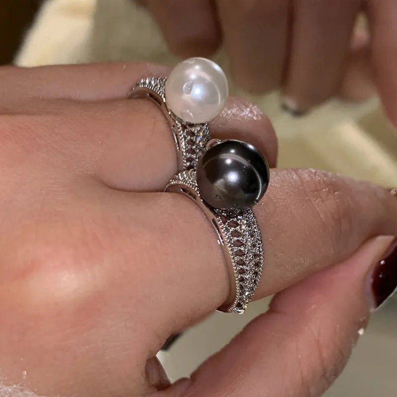 Adjustable geometric copper open finger ring in black pearl colour on grey background