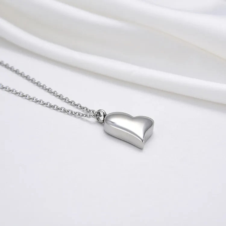 Silver coloured curved peach heart pendant necklace on a stainless steel chain with extension.