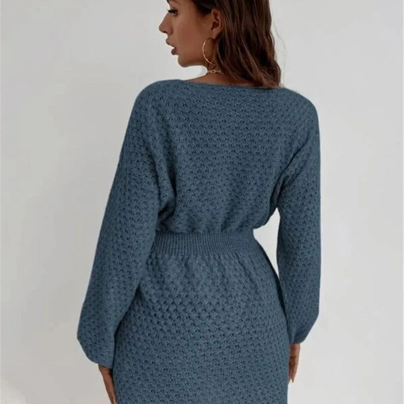 Blue women's knit dress with loose round neck, fitted waist, and hand-crocheted flower decoration
