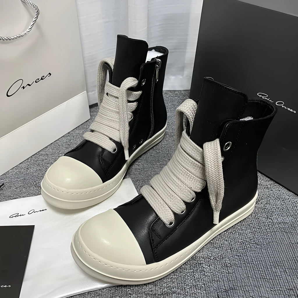 Black high-top leather sneakers with side zipper and round toe design on a white background