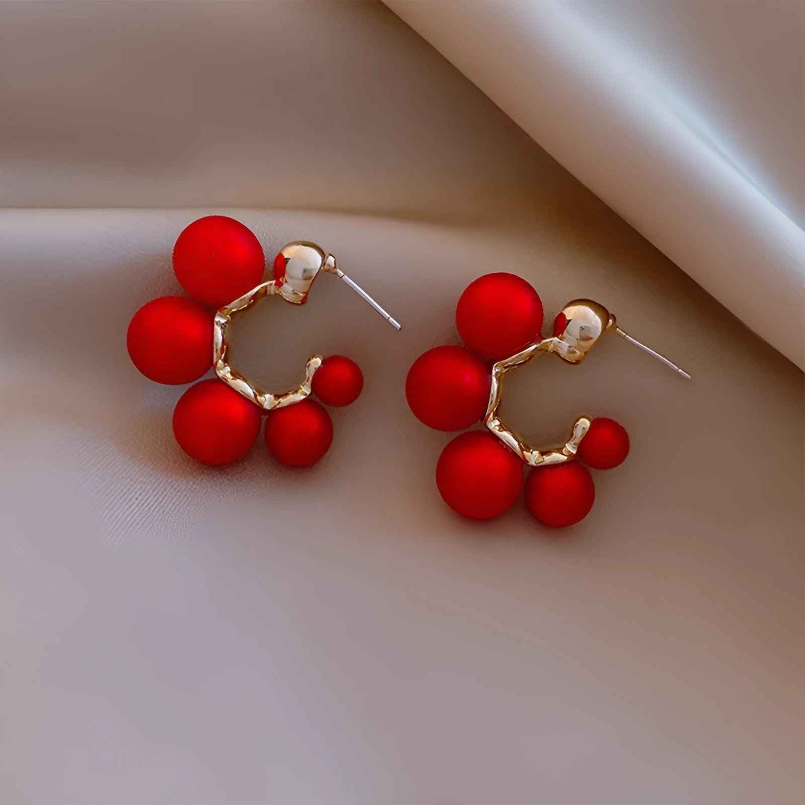 A pair of women's bell-shaped drop earrings in alloy, shown in red and white colour options.