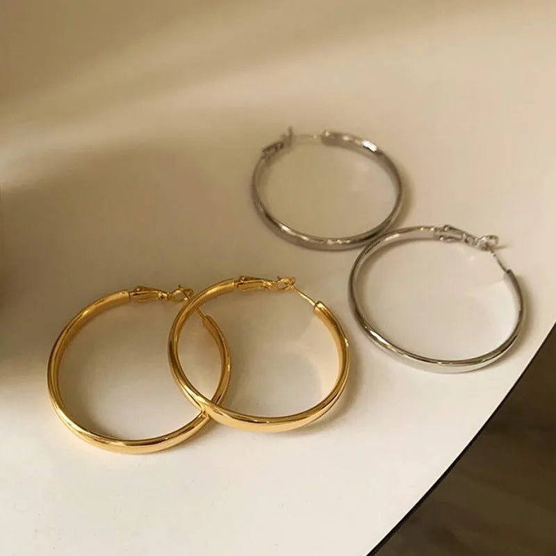 Circular copper hoop earrings with 40mm diameter in gold or silver electroplated finish