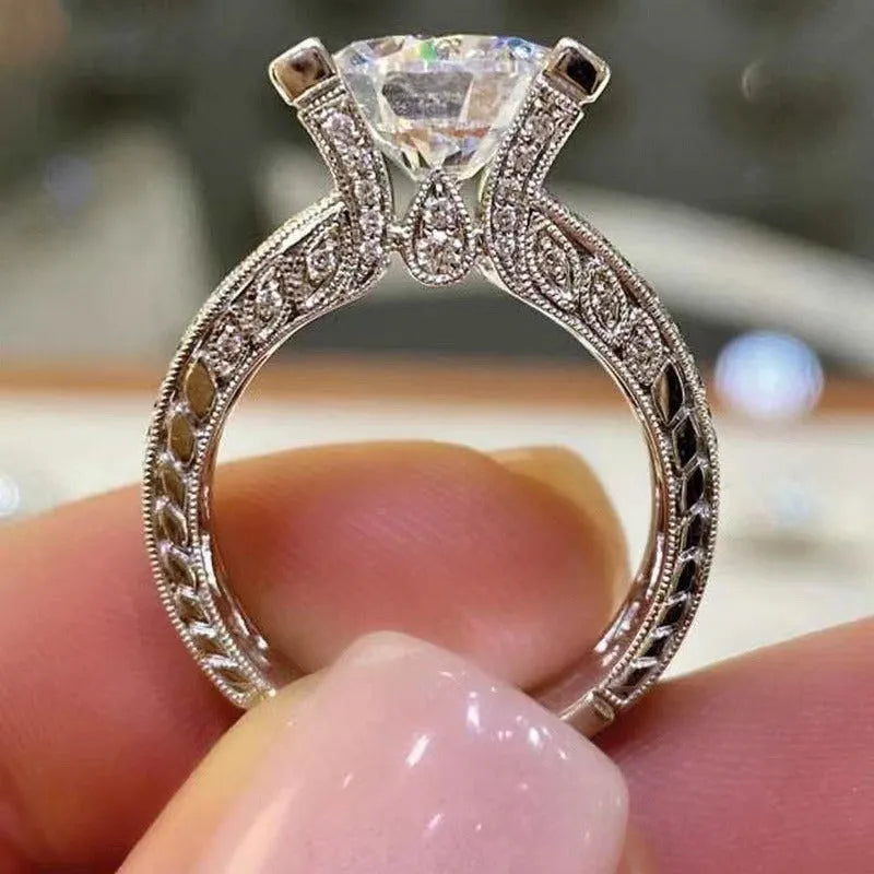 Geometric silver-coloured women's ring with round design elements on a finger, shown in gold and white colour options.
