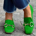 Green suede women's loafers with a metal fastener and flat rubber sole.