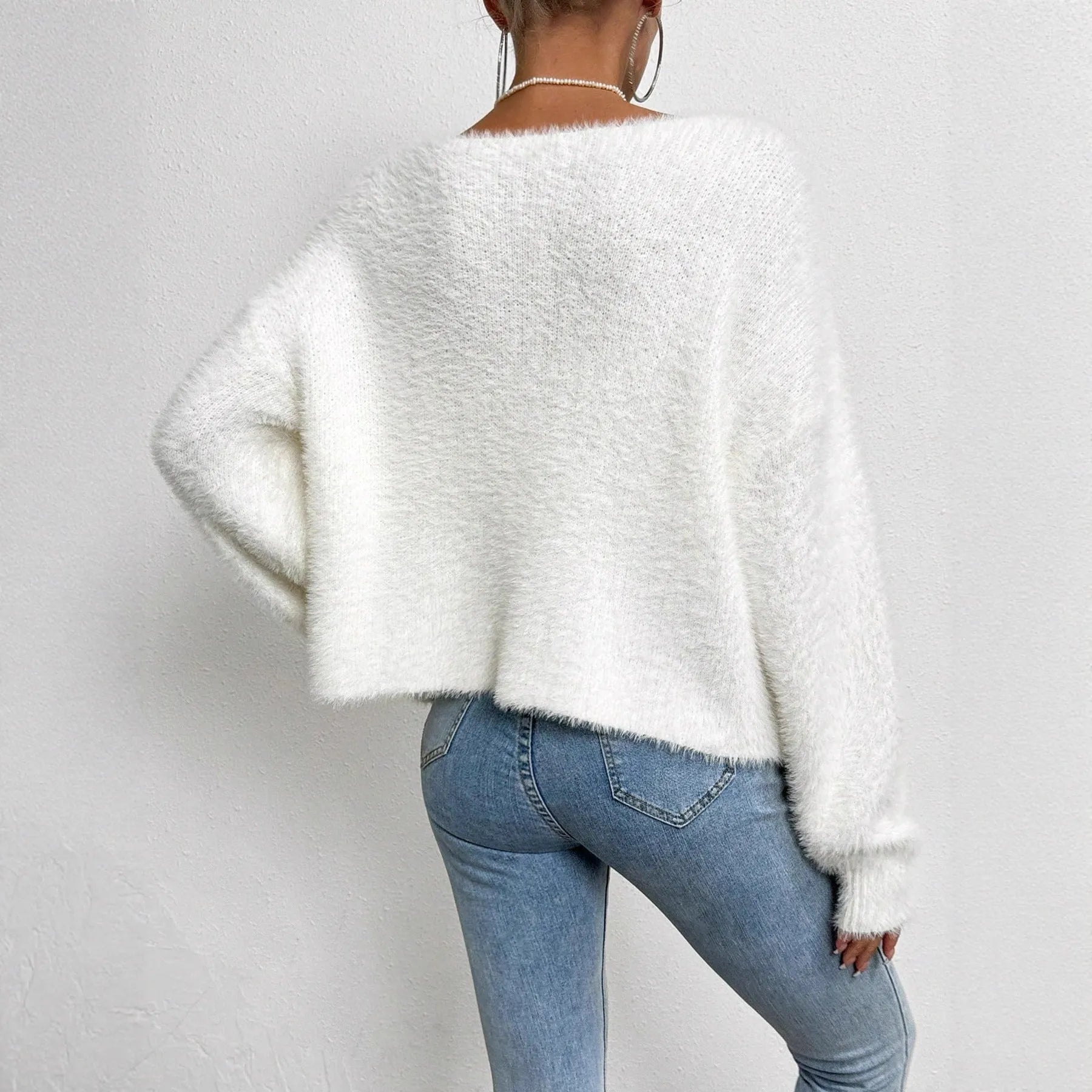 White V-neck women's cardigan sweater made from polyester knit fabric.