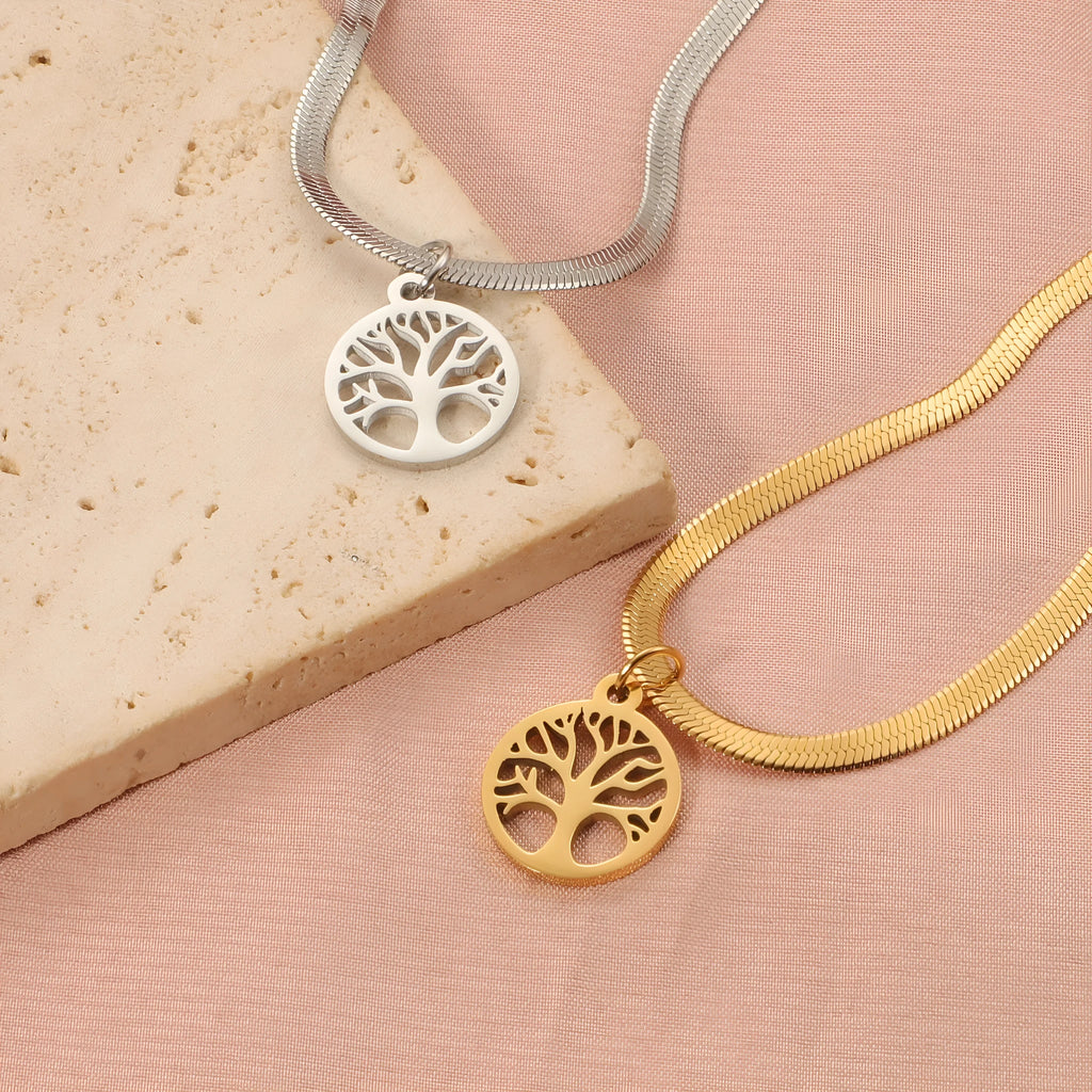 Steel colour tree pendant necklace with a textured snake bones chain on a neutral background.