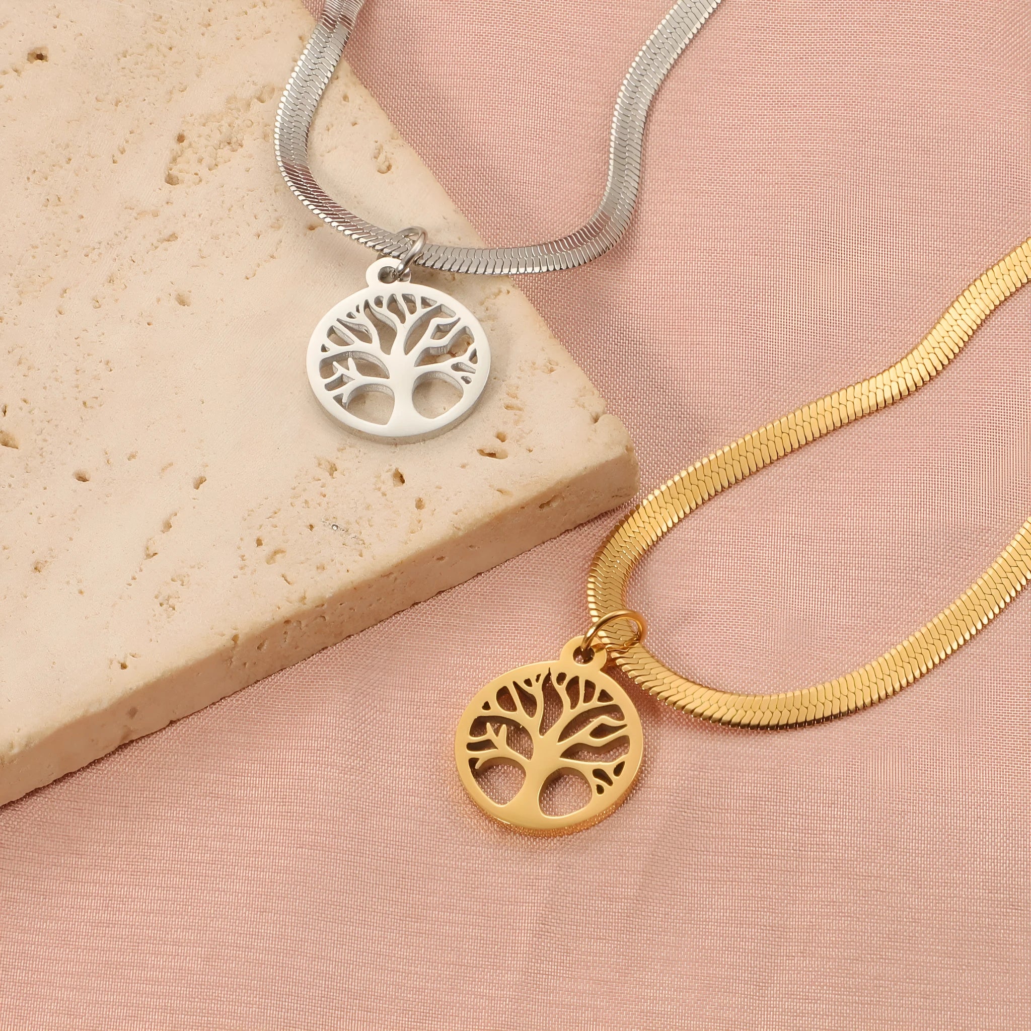 Steel colour tree pendant necklace with a textured snake bones chain on a neutral background.