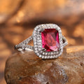 Copper square ring with red rhinestones on a woman's hand, showing geometric design.