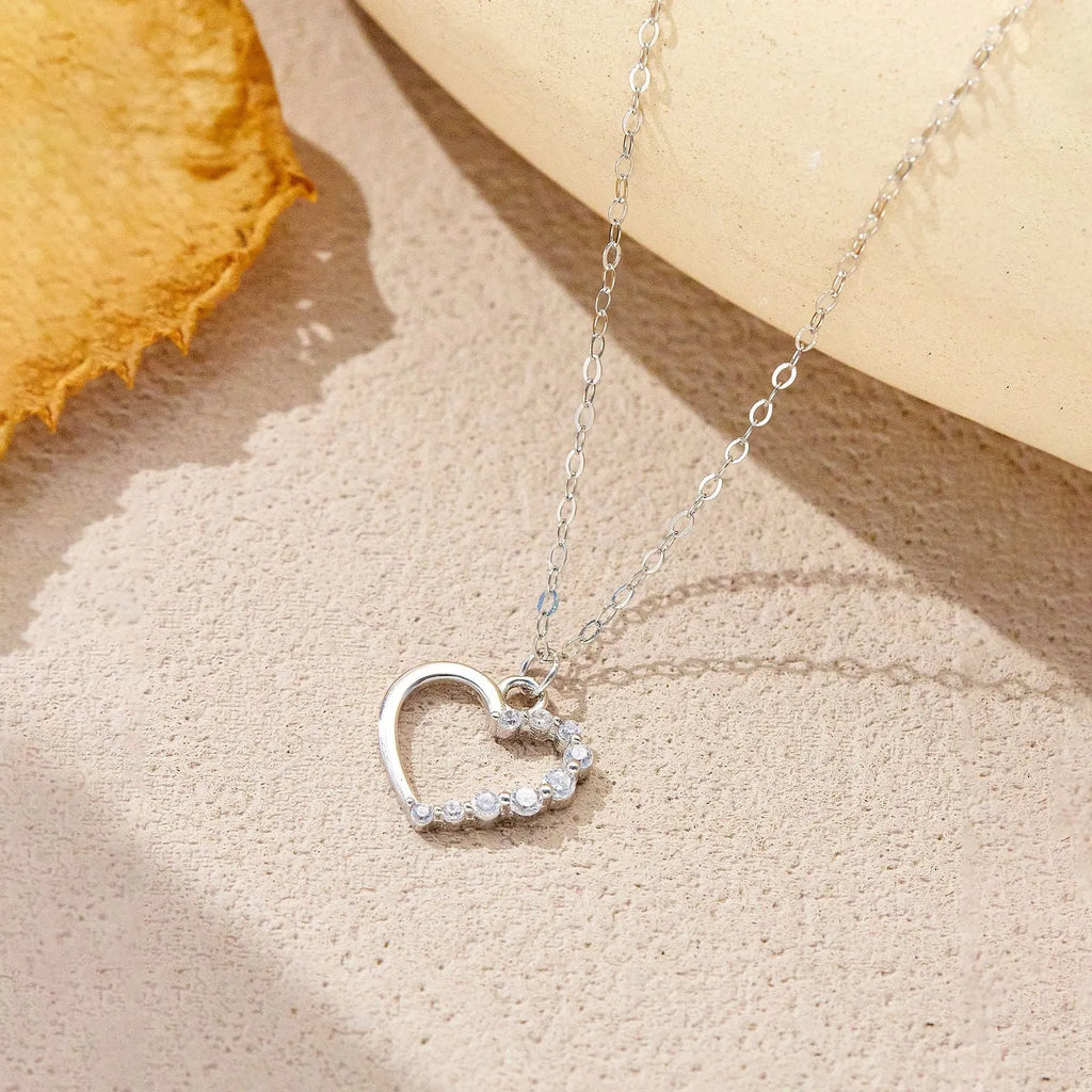 Sterling silver hollow heart pendant necklace on a regular chain, available in white gold or platinum plating.
