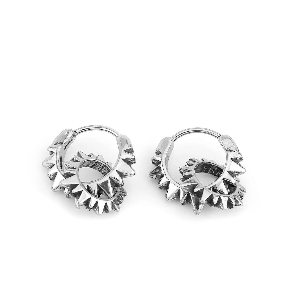 A pair of polished stainless steel round ring earrings in a retro style on a steel colour background.