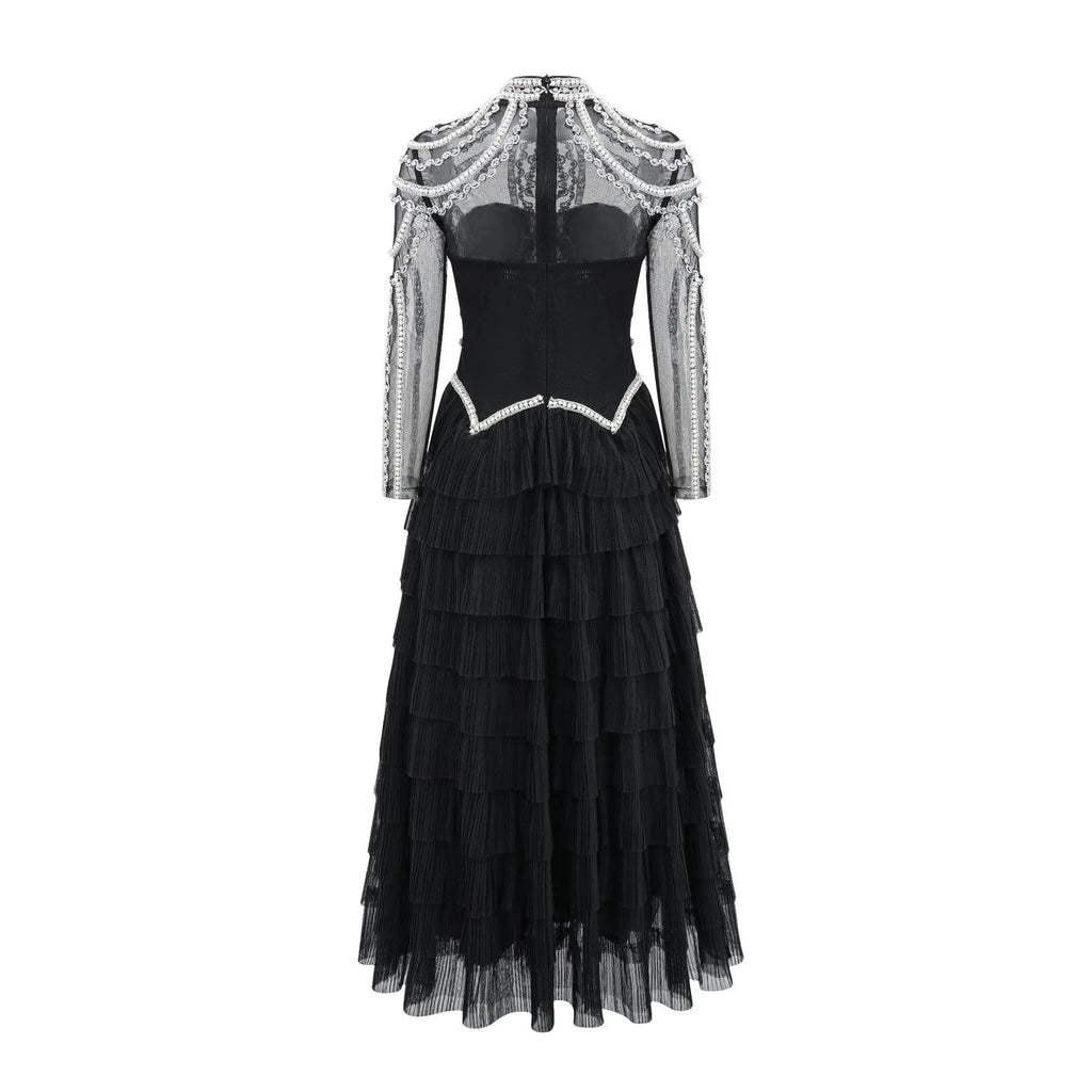Women's long sleeve black dress with beaded decoration and a full-length skirt.