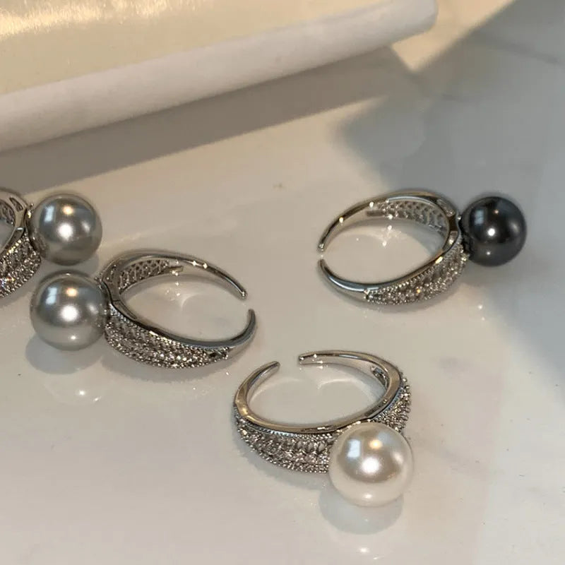 Adjustable geometric copper open finger ring in black pearl colour on grey background