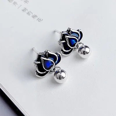 A pair of alloy lotus ear studs with retro seedpod tassel design, shown in lotus colour.