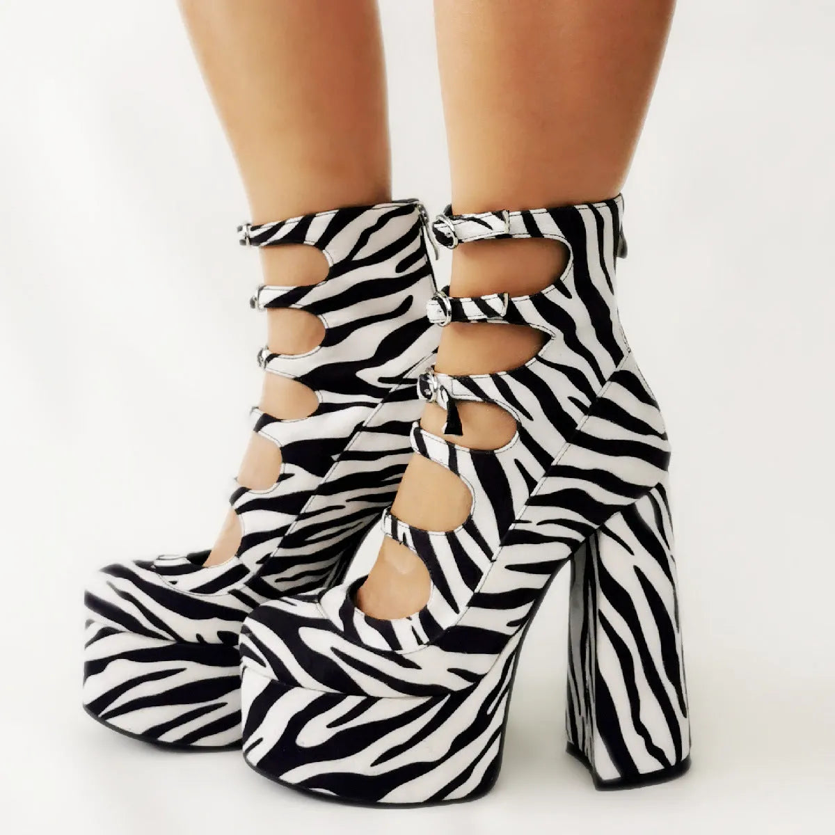 Women's black patent leather platform high-heel ankle boots with a thick heel and serpentine buckle strap.