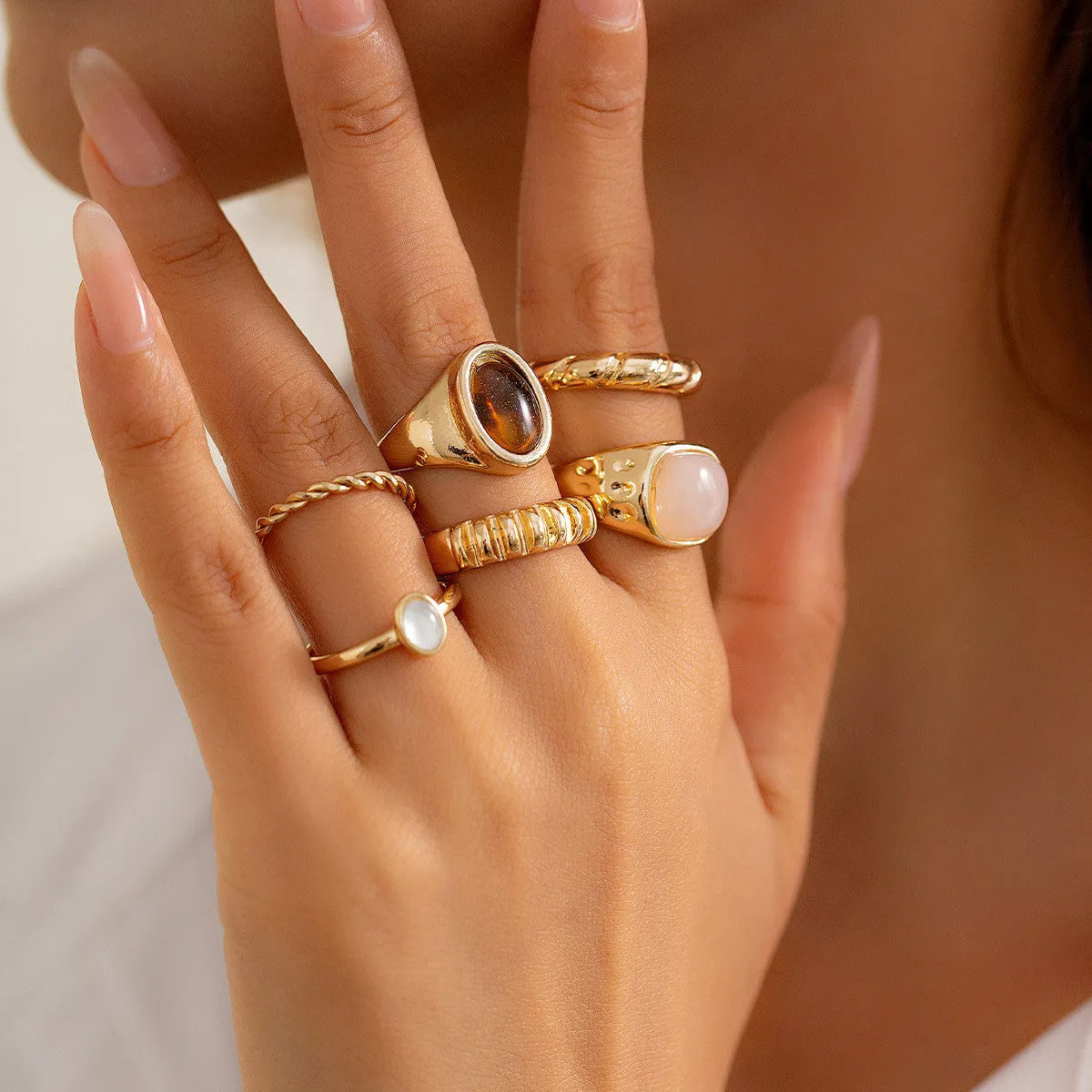 Six light gold geometric and round alloy rings for women displayed together