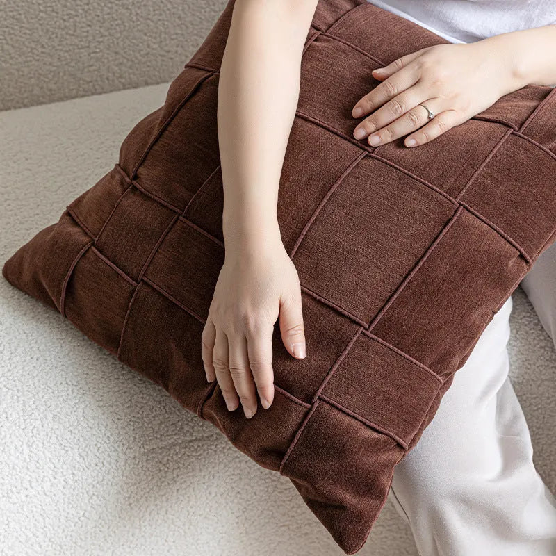 Square chenille woven sofa cushion in taupe colour on a grey sofa, showing textured fabric detail