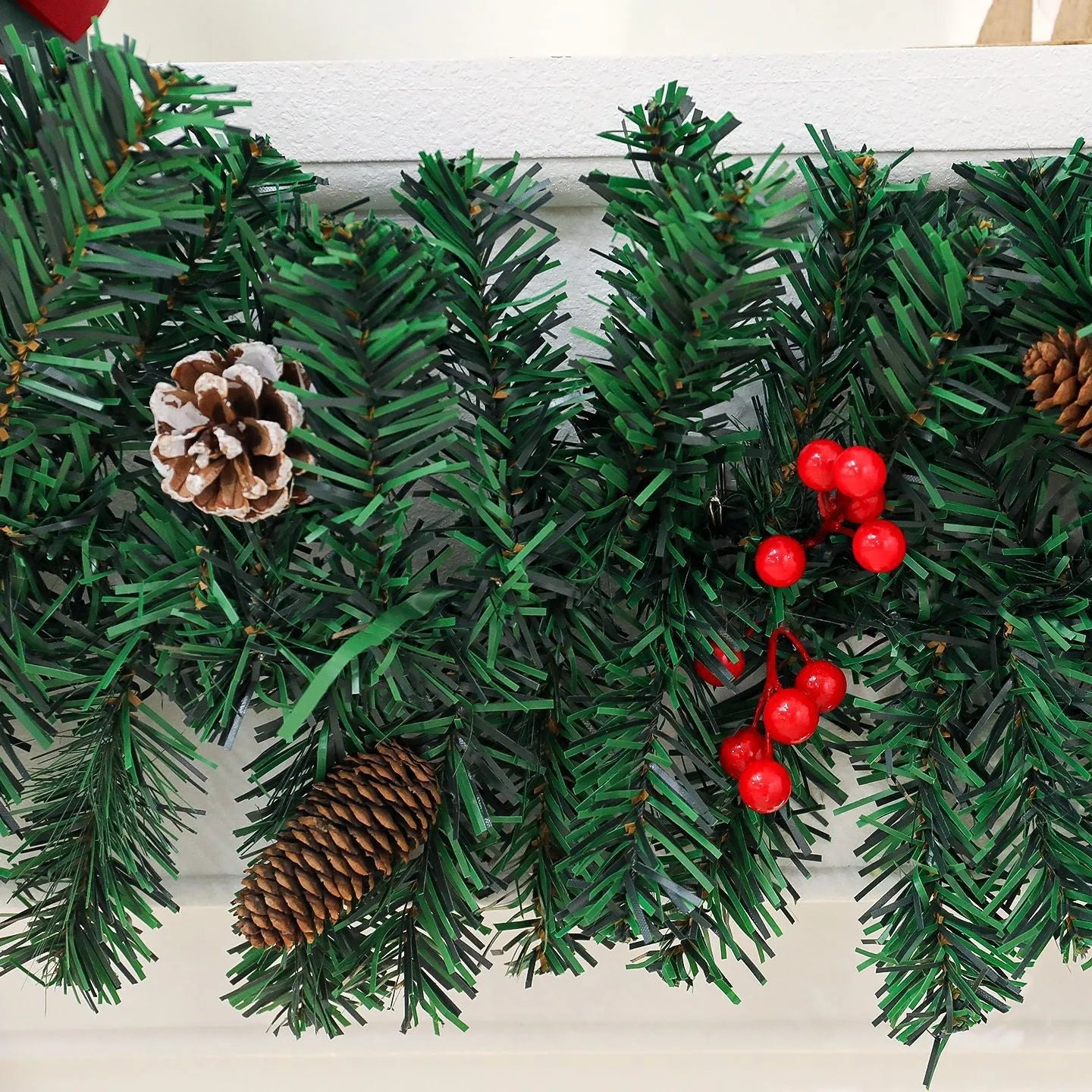 European-style rattan Christmas cane decoration with pine cone and red bow, approximately one metre tall.