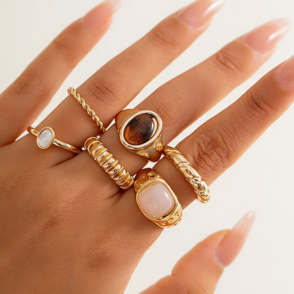 Six light gold geometric and round alloy rings for women displayed together