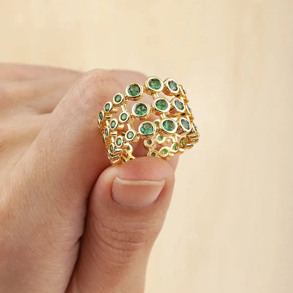 Gold-coloured wide copper ring with a large green zircon stone in a three-layer setting.