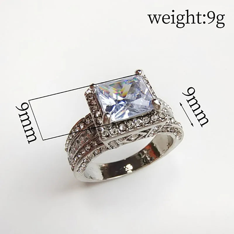 Geometric silver-coloured women's ring with round design elements on a finger, shown in gold and white colour options.