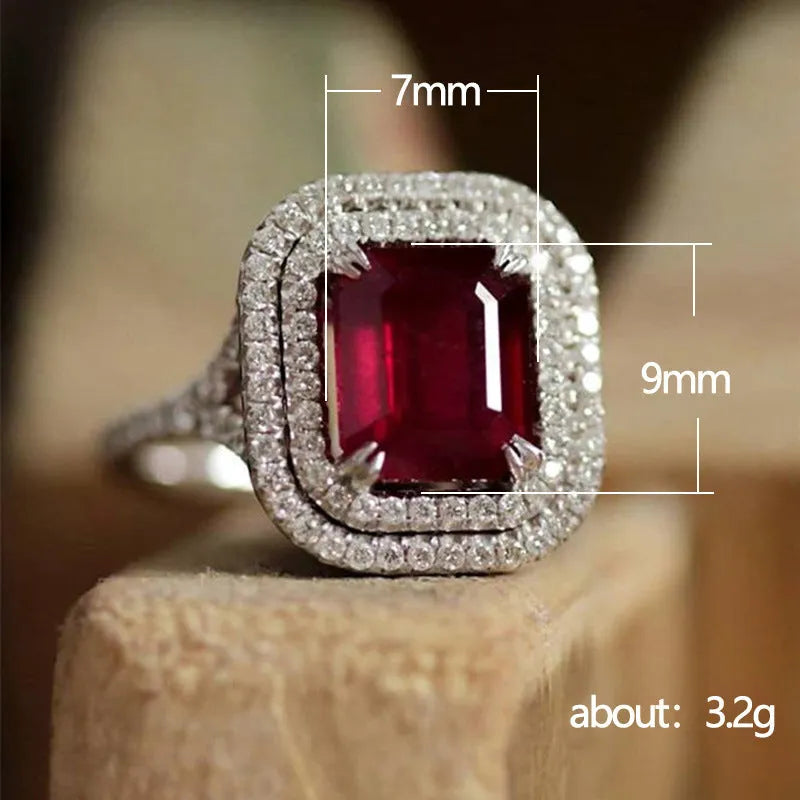 Copper square ring with red rhinestones on a woman's hand, showing geometric design.