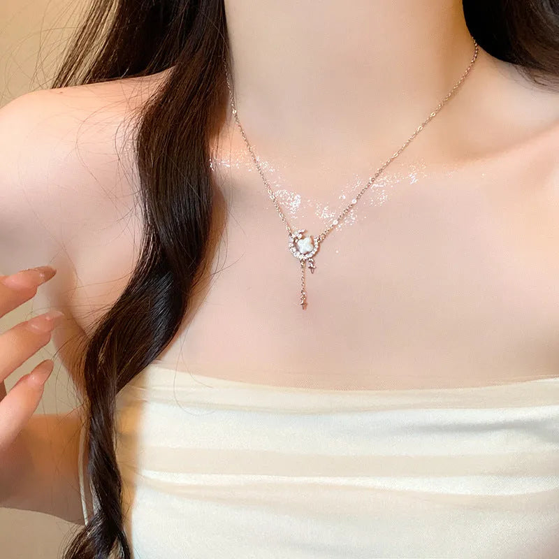 Gold-tone star and moon pendant necklace on an adjustable copper chain.