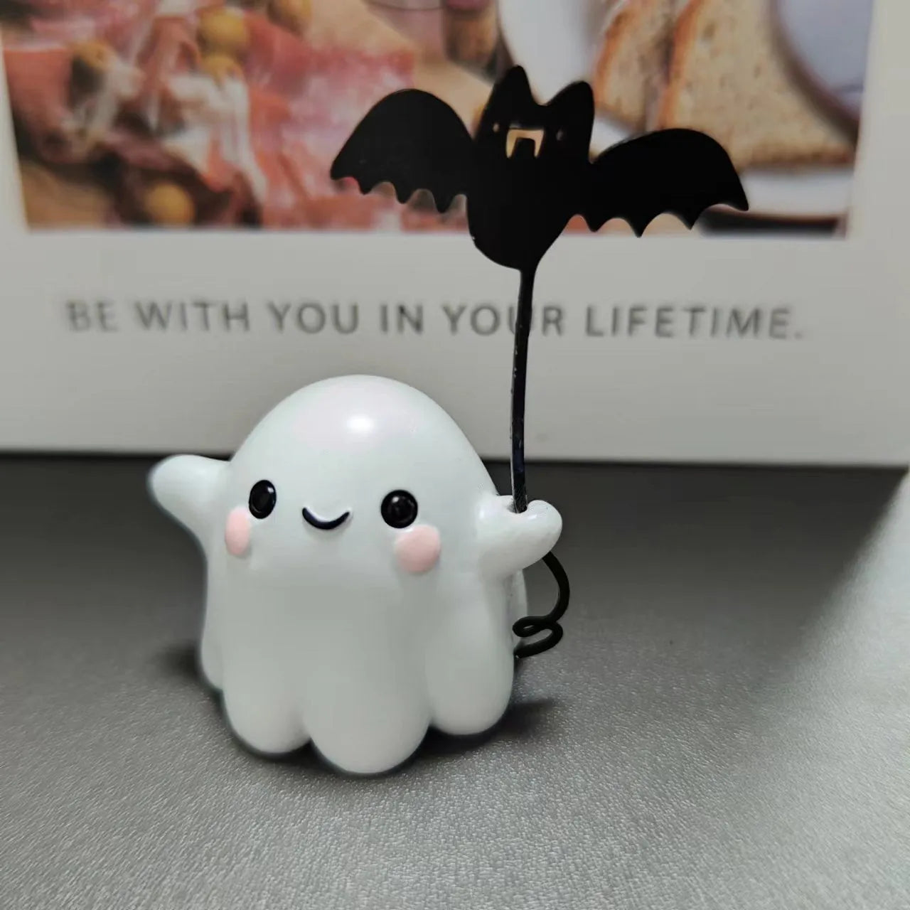 Mini resin statue of a ghost walking a dog and holding a bat, a Halloween ornament.