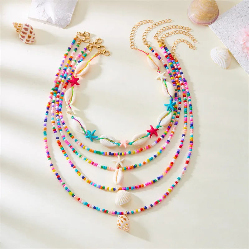Five multi-layer women's necklaces with starfish shell conch bead designs in blue and mixed colours
