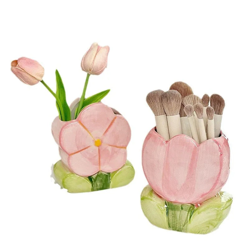 Ceramic pen holder storage box with floral decoration on desk.