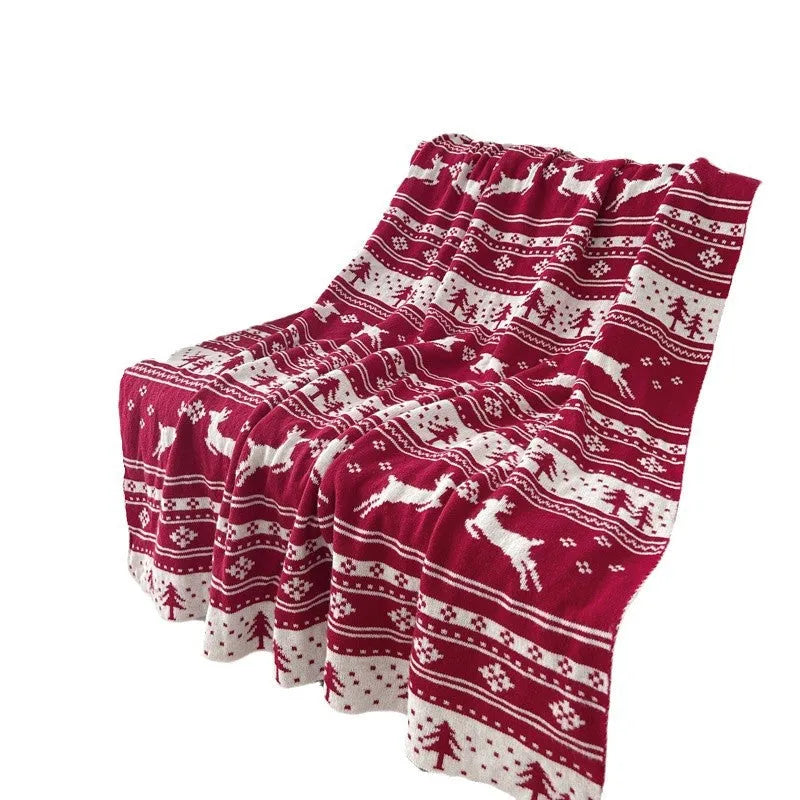Personalised acrylic Christmas blanket with snowflake or reindeer pattern on a sofa.