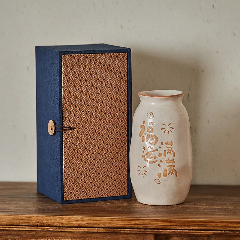 Chinese hand-painted ceramic joy vase with carved decorations on wooden desktop