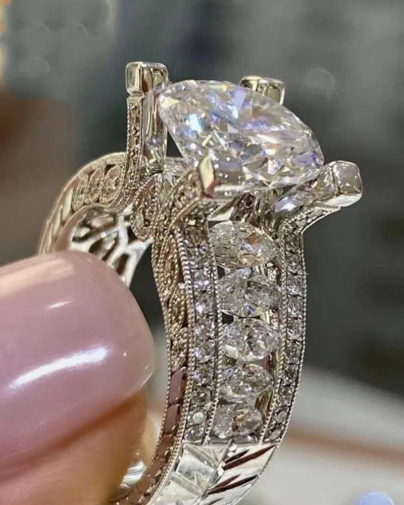 Geometric silver-coloured women's ring with round design elements on a finger, shown in gold and white colour options.