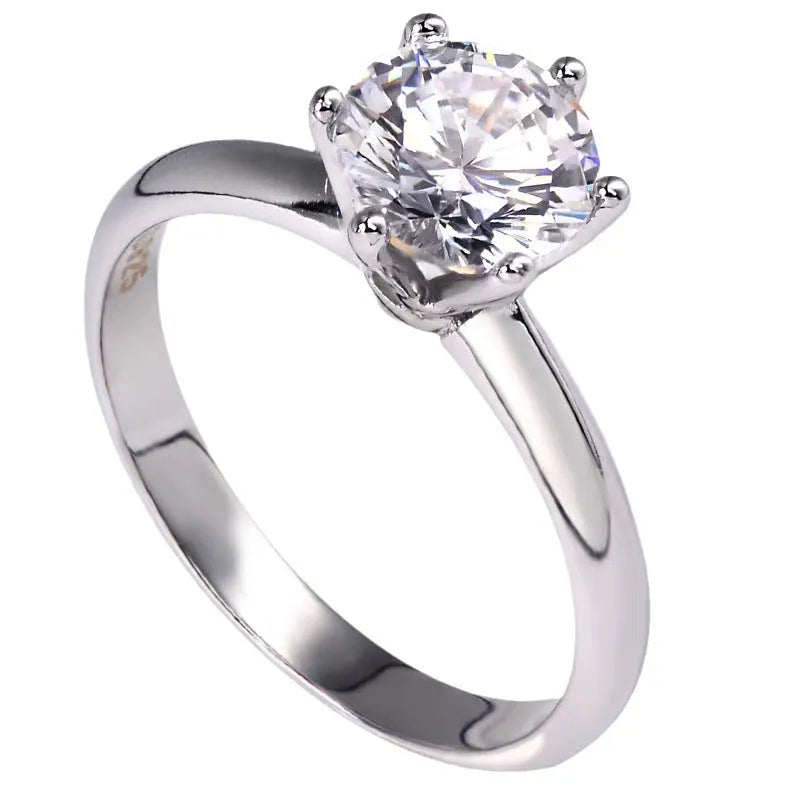 White gold plated geometric ring with six-claw setting holding a zircon stone.