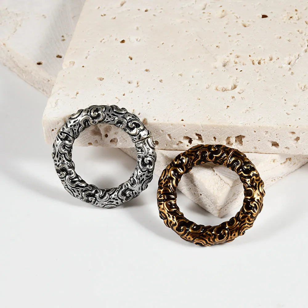 A pair of stainless steel fashion earrings featuring a shaped totem pattern in an electroplated finish.
