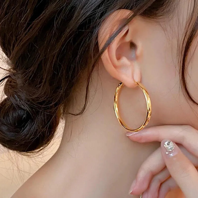 Circular copper hoop earrings with 40mm diameter in gold or silver electroplated finish