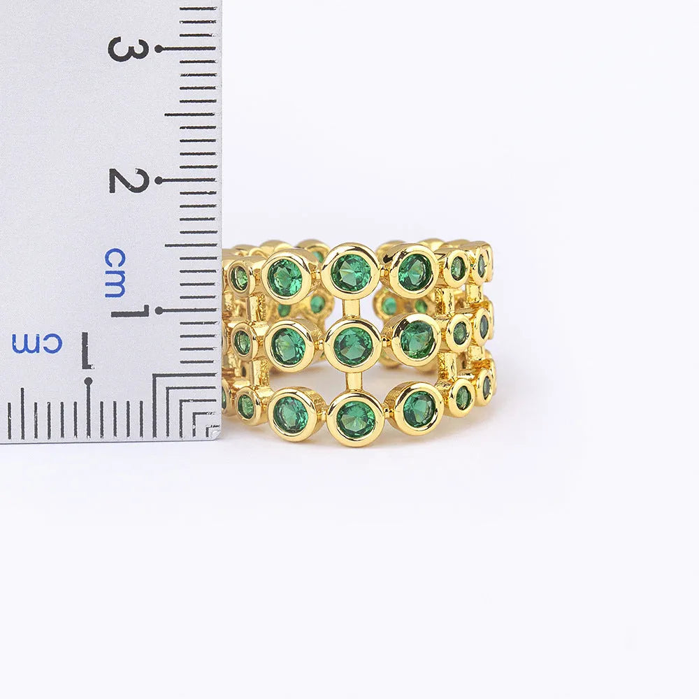 Gold-coloured wide copper ring with a large green zircon stone in a three-layer setting.
