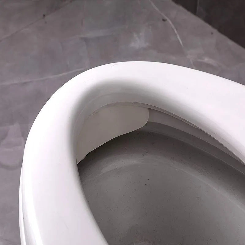 White PVC toilet training splash guard placed on a toilet seat.