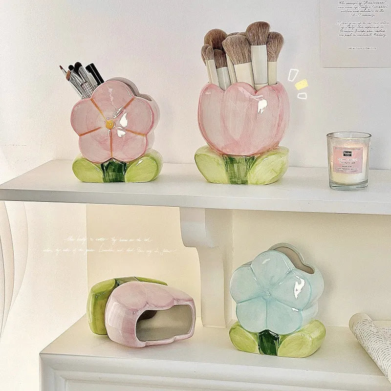 Ceramic pen holder storage box with floral decoration on desk.
