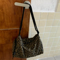 Leopard print crossbody messenger bag with stitching details and shoulder strap