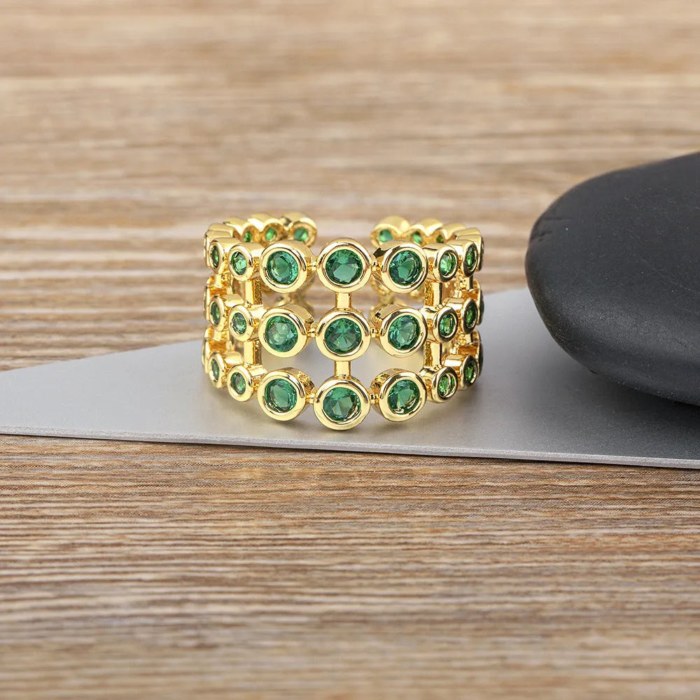 Gold-coloured wide copper ring with a large green zircon stone in a three-layer setting.