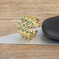 Gold-coloured wide copper ring with a large green zircon stone in a three-layer setting.