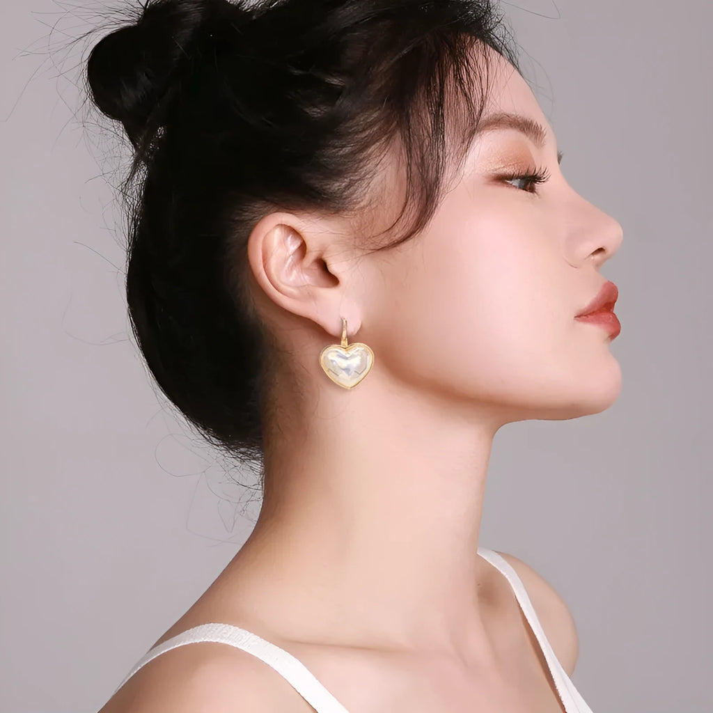 A pair of gold-coloured clip-on earrings with a metallic finish and natural styling.