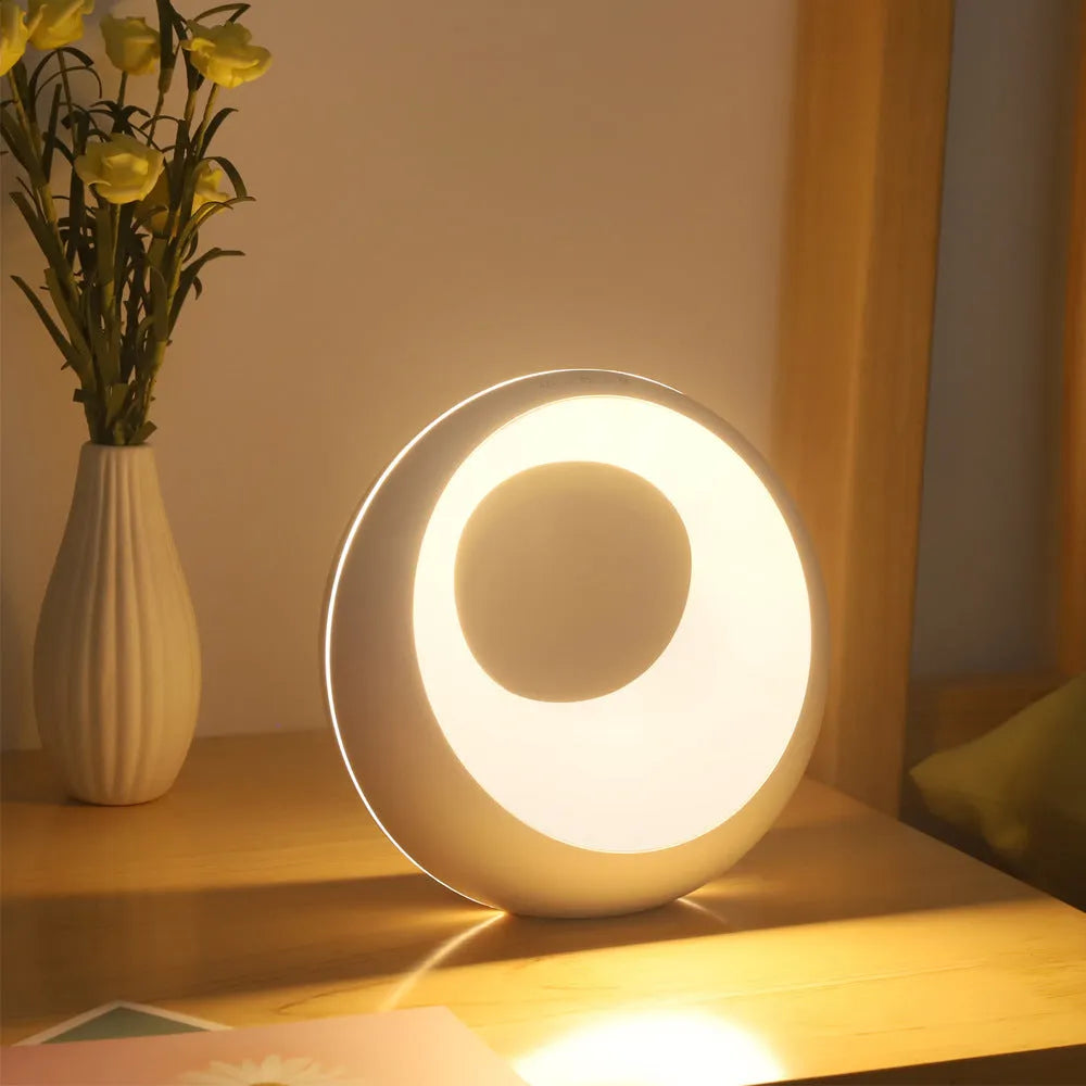 Small white RGB colour changing desk lamp with remote control on wooden surface